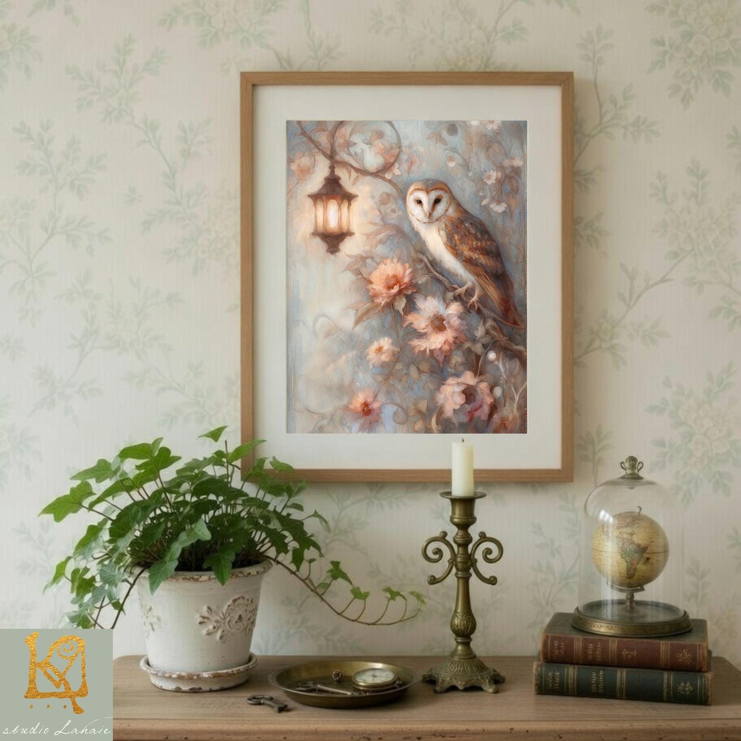 a framed painting of an owl perched on a branch with flowers, a potted plant, a candle, and some books on a shelf.