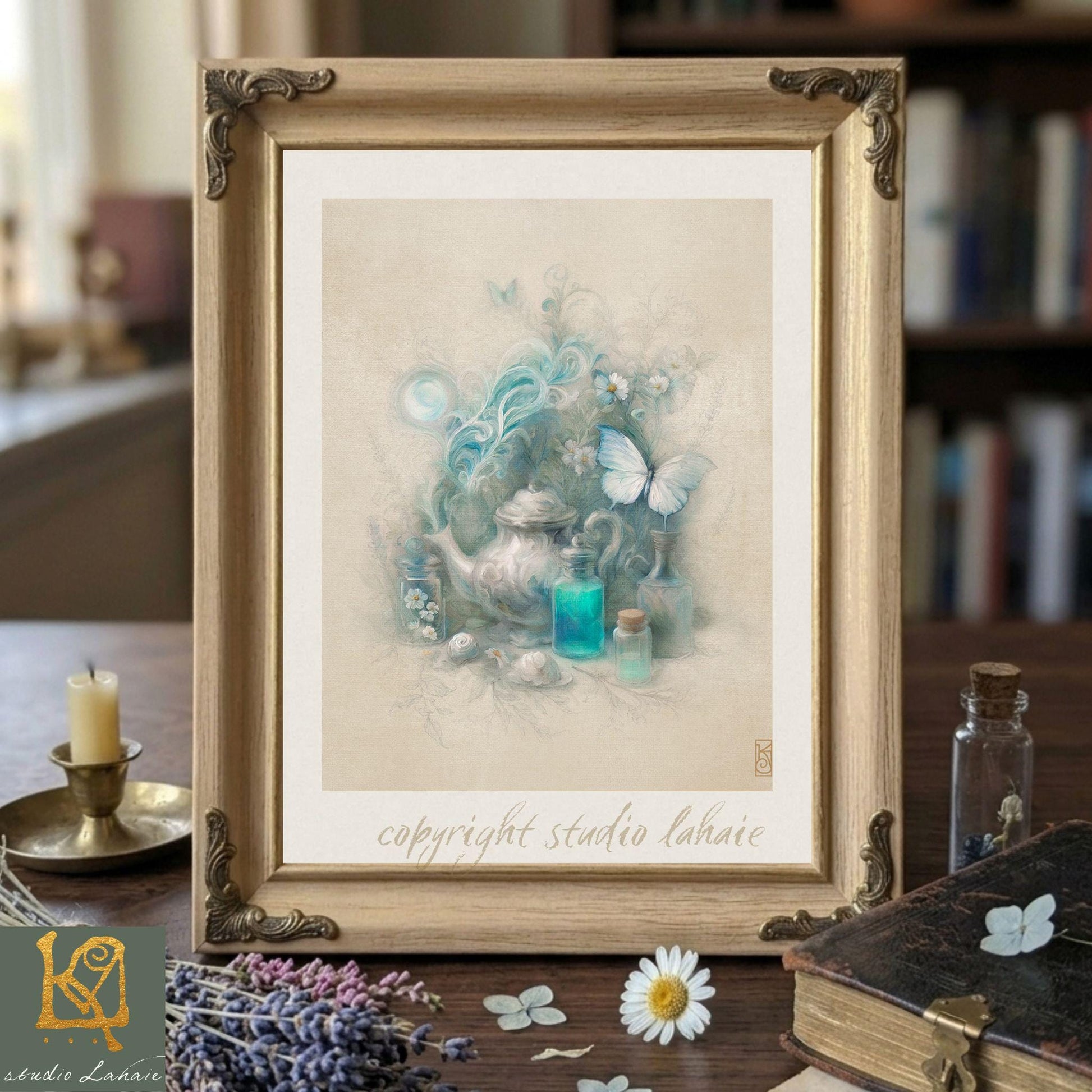 a framed artwork depicting a teapot surrounded by flowers and butterflies, placed on a wooden surface with various objects such as a candle, a book, and a vase.