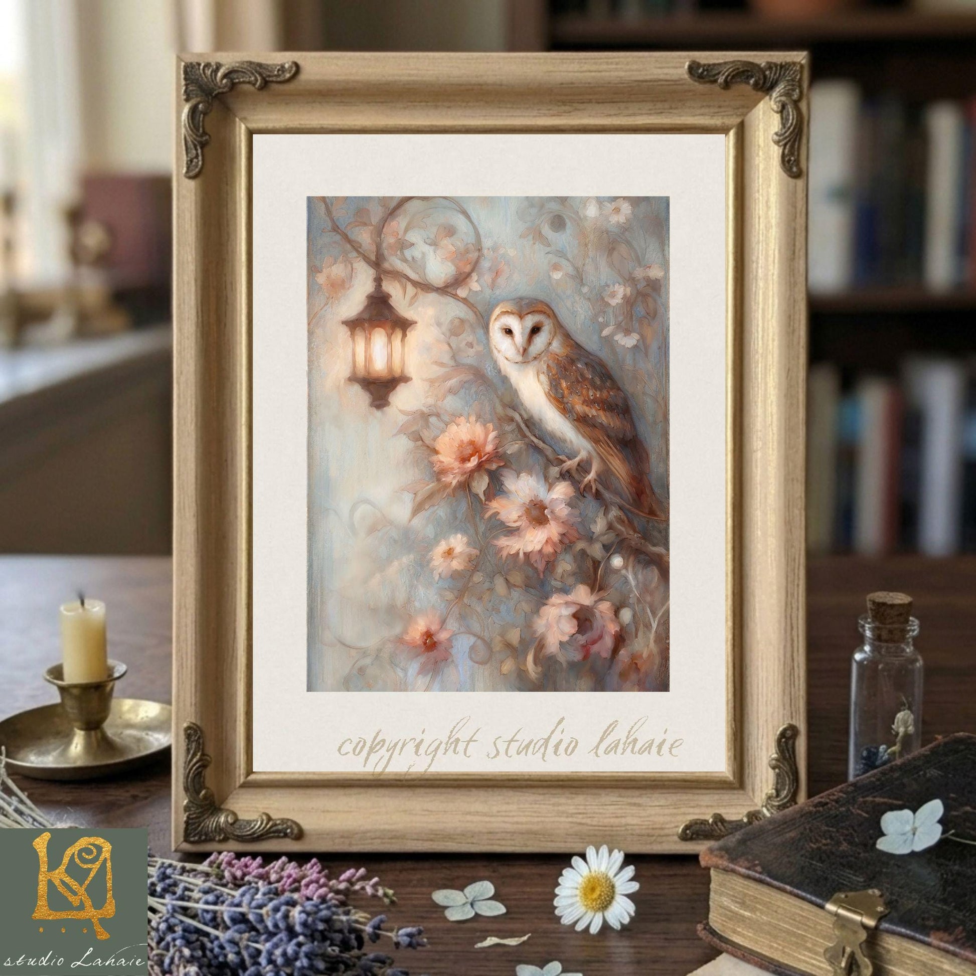 a framed painting of an owl perched on a branch with flowers, placed on a wooden surface. The painting is surrounded by various objects, including a candle, a book, and some flowers.