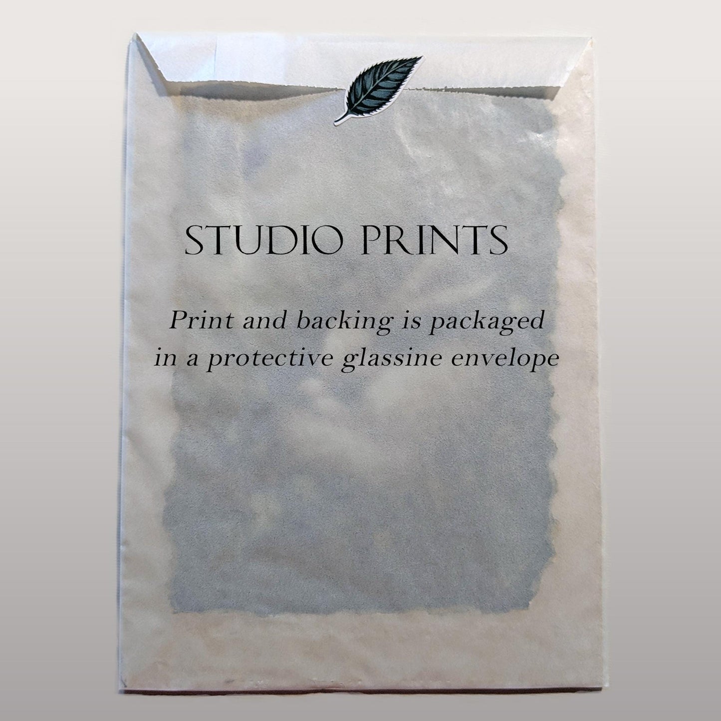 The image is a plain white envelope with text printed on it, and there is a leaf sticker on the top.