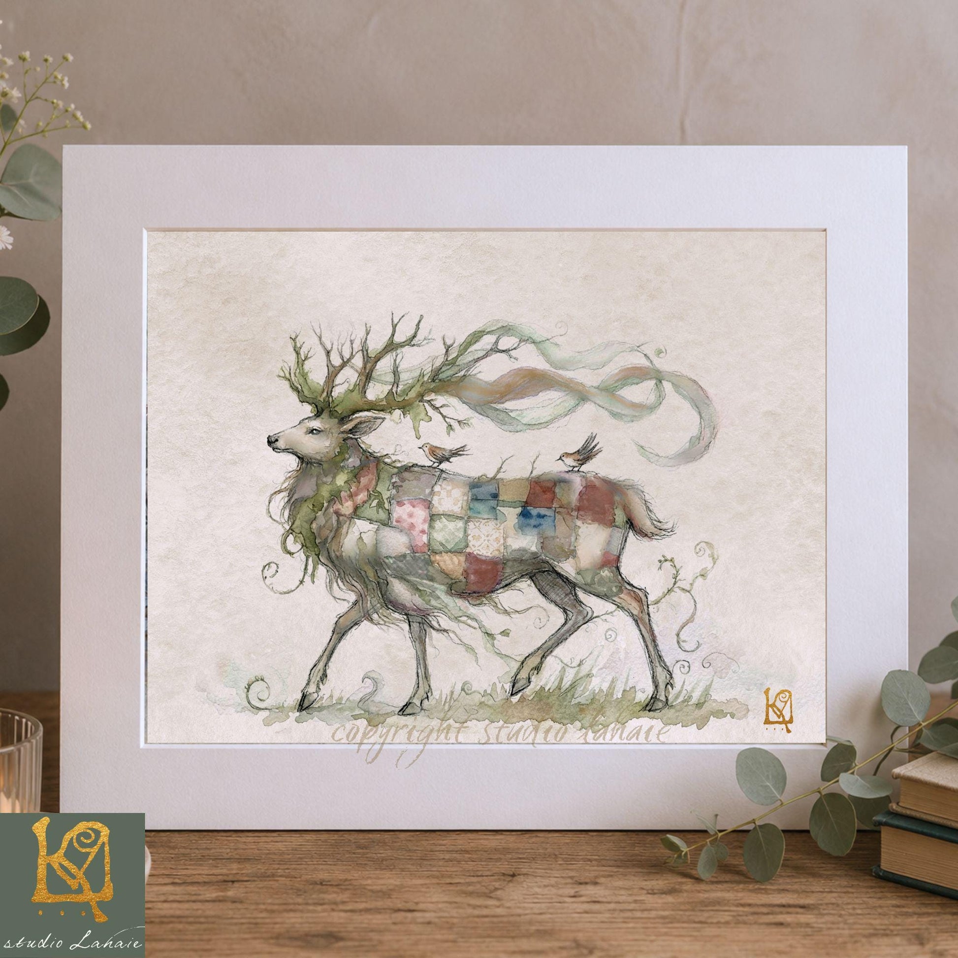 A framed illustration of a deer with a colorful, patterned coat, standing in a grassy field with a bird perched on its back.
